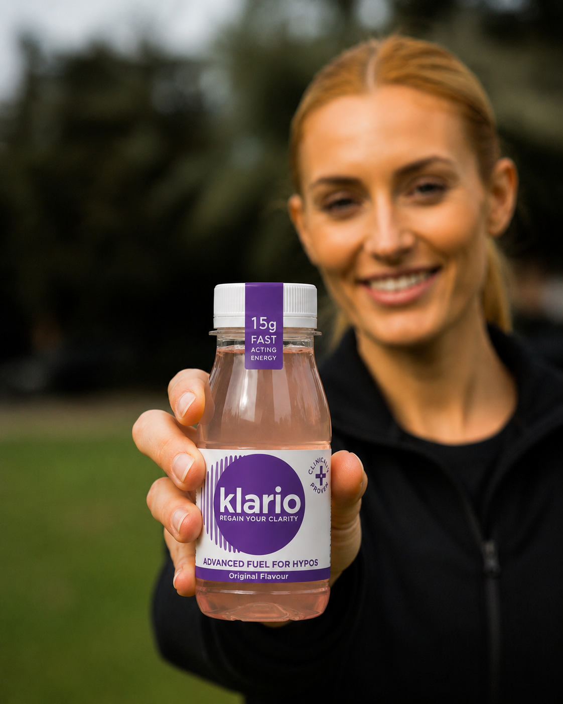 A woman holding up a bottle of Klario