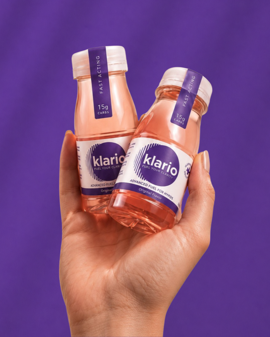 A hand holding two bottles of Klario